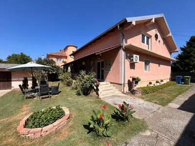 a house with an umbrella and a yard with plants at Apart Zen House in Borča