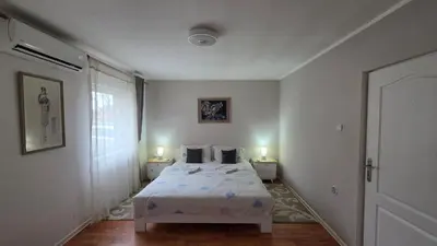 a bedroom with a bed and two lamps on two tables at Apart Zen House in Borča