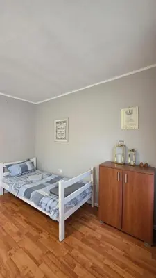 a bedroom with a bed and a wooden cabinet at Apart Zen House in Borča