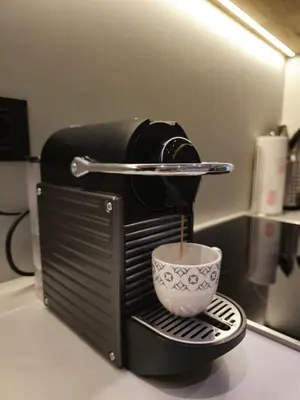 a coffee maker with a cup on a counter at DM apartman Belgrade Waterfront in Sajmište