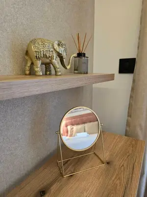 a mirror on a table with a elephant on a shelf at DM apartman Belgrade Waterfront in Sajmište