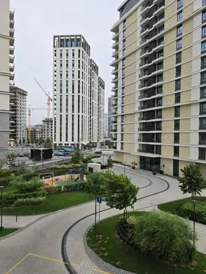 an empty street in a city with tall buildings at DM apartman Belgrade Waterfront in Sajmište