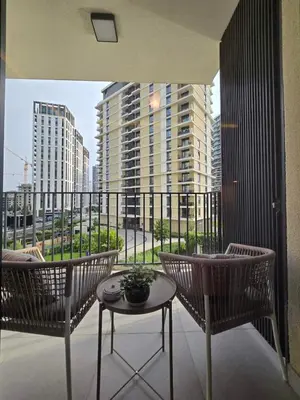 a balcony with two chairs and a table and some buildings at DM apartman Belgrade Waterfront in Sajmište