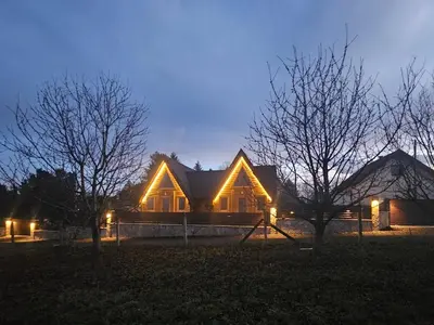 a house with lights on the front of it at night at Vila Banstolija in Velika Remeta