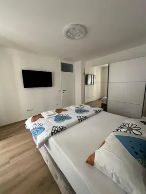 a bedroom with two beds and a flat screen tv at Apartman Aranđelovac in Arandjelovac