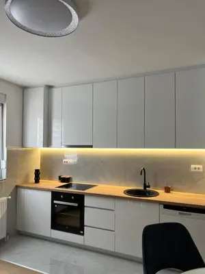 a kitchen with white cabinets and a sink at Apartman Aranđelovac in Arandjelovac