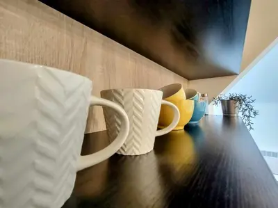 two white coffee mugs sitting on a wooden table at Studio Bajka in Kanarevo Brdo