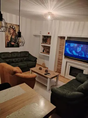 a living room with couches and a large television at Bella Lux Centar in Mladenovac