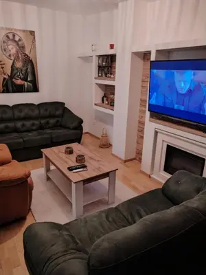 a living room with a couch and a tv and a table at Bella Lux Centar in Mladenovac