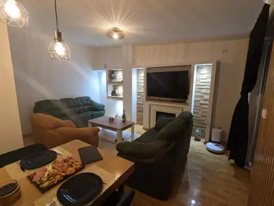 a living room with couches and a table and a television at Bella Lux Centar in Mladenovac