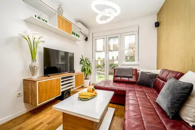 a living room with a couch and a tv at Apartment Urban Garden in Belgrade