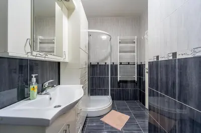 a bathroom with a sink and a toilet and a mirror at Apartment Urban Garden in Belgrade