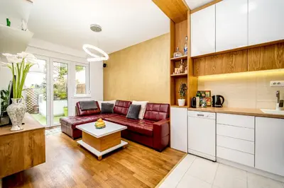 a kitchen and living room with a red couch at Apartment Urban Garden in Belgrade