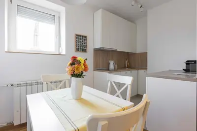 a kitchen with a table with a vase of flowers on it at Apartment Artistique in Belgrade