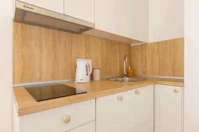 a kitchen with white cabinets and a sink at Apartment Artistique in Belgrade