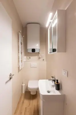 a white bathroom with a toilet and a sink at Apartment Artistique in Belgrade