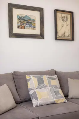 a gray couch with two pictures on the wall at Apartment Artistique in Belgrade