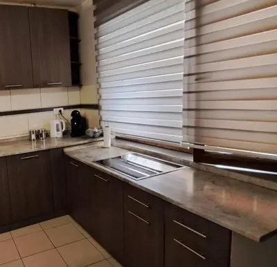 a kitchen with wooden cabinets and a counter top at Lola in Voždovac