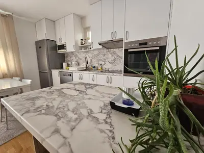 a kitchen with a large marble counter top at Airport Apartment in Surčin