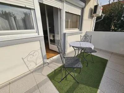 a patio with two chairs and a table on a balcony at Airport Apartment in Surčin