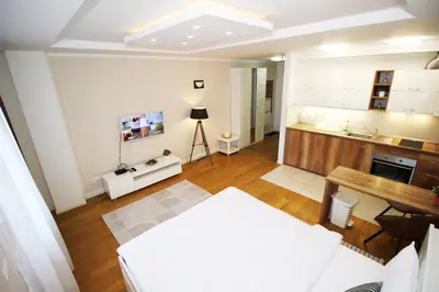 a living room with a table and a kitchen at Apartment A Block Nota Delta City New Belgrade in Novi Beograd