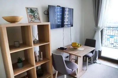 a room with a desk and a table with chairs at Verde Comfortable Apartment in Belgrade