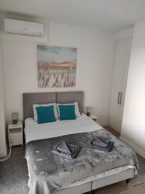 a bedroom with a large bed with blue pillows at Verde Comfortable Apartment in Belgrade