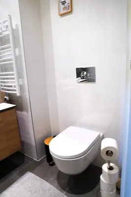 a bathroom with a white toilet and a sink at Verde Comfortable Apartment in Belgrade