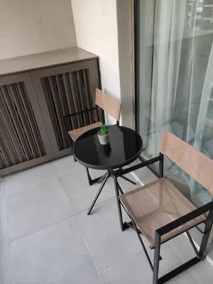 a black table and two chairs on a balcony at Verde Comfortable Apartment in Belgrade