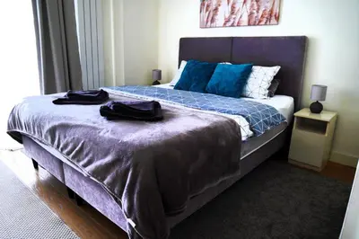 a bedroom with a large bed with blue pillows at Verde Comfortable Apartment in Belgrade
