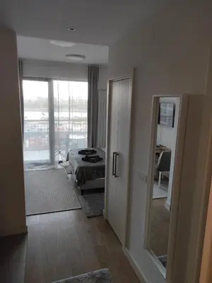 a bedroom with a bed and a view of a room at Verde Comfortable Apartment in Belgrade