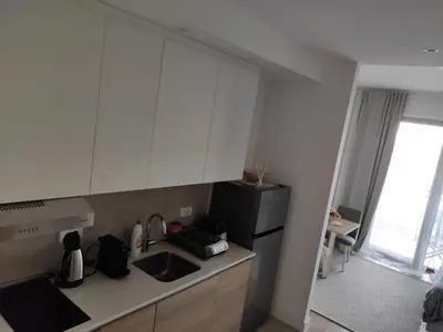 a kitchen with white cabinets and a black refrigerator at Verde Comfortable Apartment in Belgrade