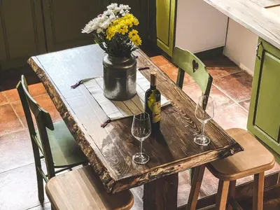 a wooden table with two wine glasses and a vase of flowers at Wood Mood Apartman Tiganjica in Staji°evo