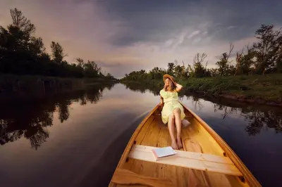a woman sitting in a boat on a river at Wood Mood Apartman Tiganjica in Staji°evo