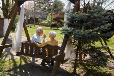 an older man and a child sitting on a swing at Wood Mood Apartman Tiganjica in Staji°evo