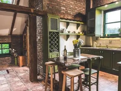 a kitchen with a table and chairs and a brick wall at Wood Mood Apartman Tiganjica in Staji°evo
