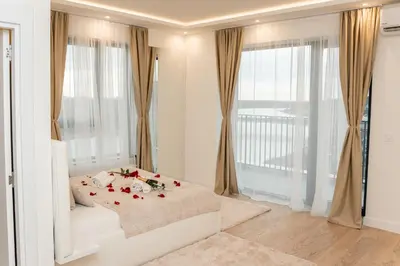 a bedroom with a bed and a large window at SINFONIA LUX in Belgrade
