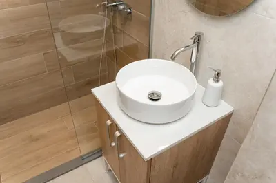a bathroom with a white sink and a shower at SINFONIA LUX in Belgrade