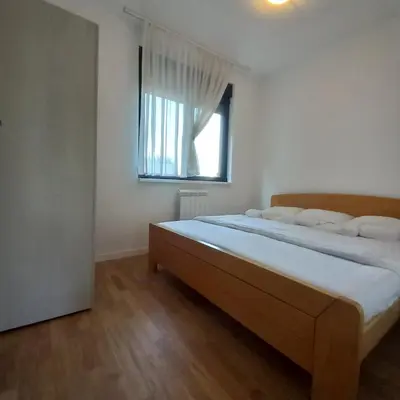 a bedroom with a large bed with a window at RIVIJERA CITY in Belgrade