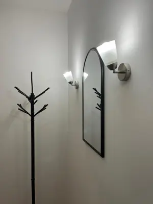 a mirror and a lamp with a cross on a wall at MinuteToRiver Apartment in Belgrade