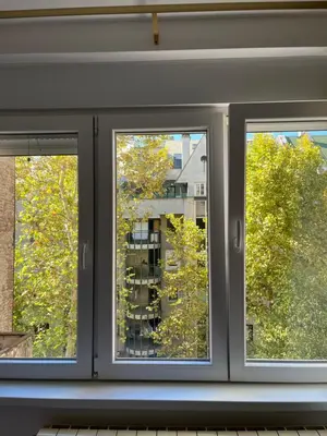 a window with three views of a building at MinuteToRiver Apartment in Belgrade