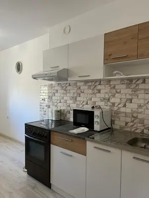 a kitchen with white cabinets and a black stove top oven at MinuteToRiver Apartment in Belgrade