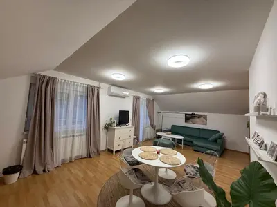 a living room with a green couch and a table at Apartman Magnolia in Zemun