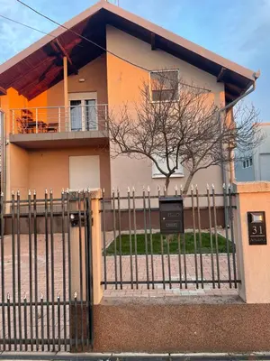 a house with a fence in front of it at Apartman Magnolia in Zemun