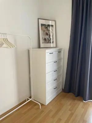 a dresser with a picture on top of it in a bedroom at Apartman Magnolia in Zemun