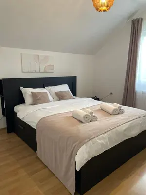 a bedroom with a large bed with two towels on it at Apartman Magnolia in Zemun