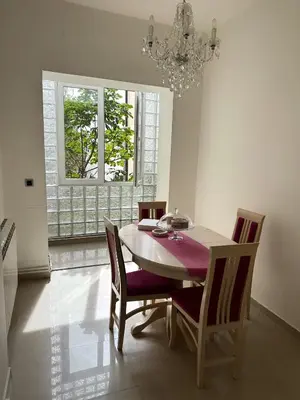 a dining room with a table and chairs and a chandelier at VRACAR Apartment in Belgrade
