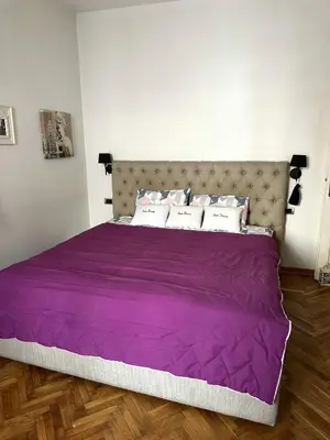 a purple bed in a white room with at VRACAR Apartment in Belgrade