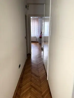 an empty room with a hallway with a hard wood floor at VRACAR Apartment in Belgrade