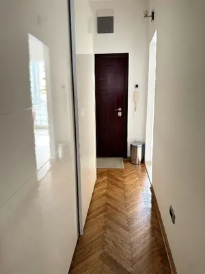 a hallway with a brown door and a wooden floor at VRACAR Apartment in Belgrade